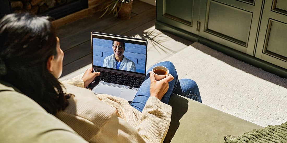 A person on a sofa during a relaxed video consultation