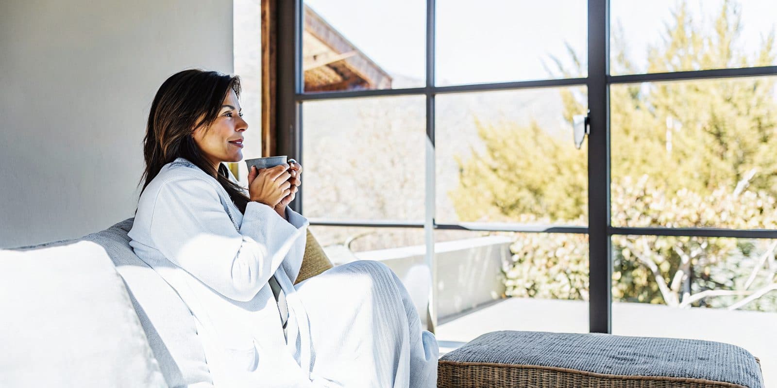 A woman relaxing at home with a warm cup of tea